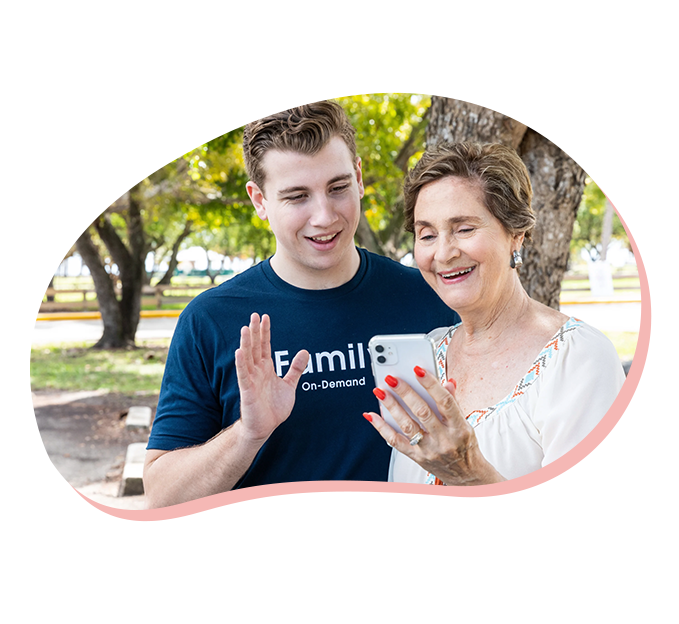 Papa pal and member in a park waving while on a video phone call